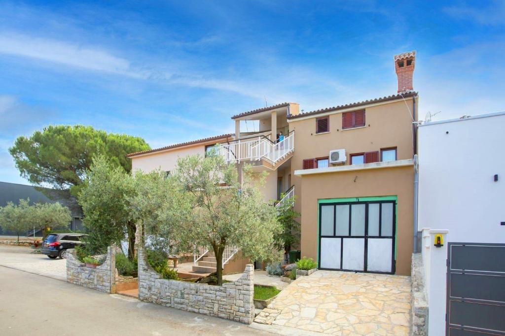 une grande maison avec un garage dans une rue dans l'établissement Apartments Armando, à Fažana