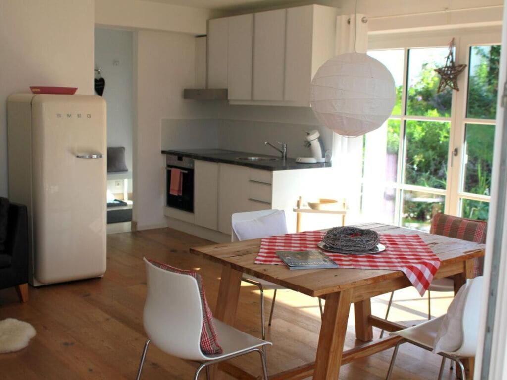 a kitchen with a wooden table with chairs and a refrigerator at Lovely apartment in Ofterschwang in Ofterschwang