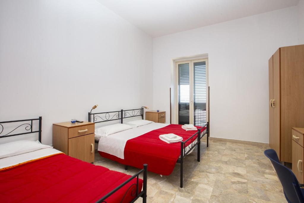 - une chambre avec 2 lits et des draps rouges dans l'établissement Casa D'alunzio - appartamento 1, à San Marco dʼAlunzio