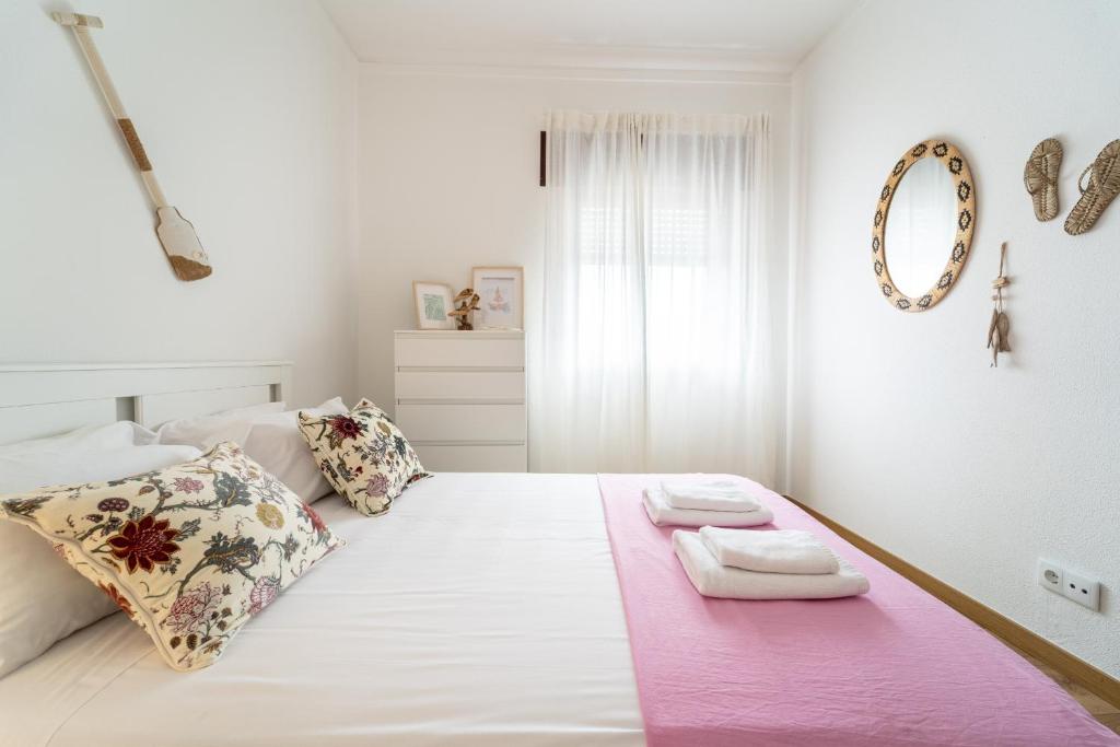 a white bedroom with a large bed with towels on it at Casino and Beach Apartment by House and People in Póvoa de Varzim