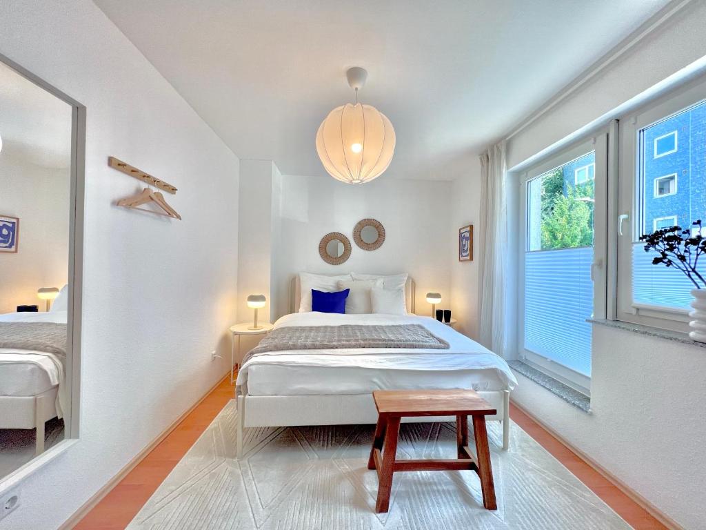 een witte slaapkamer met een bed en een raam bij TIMELESS APARTMENT: FREE PARKING + BALCONY in Wuppertal