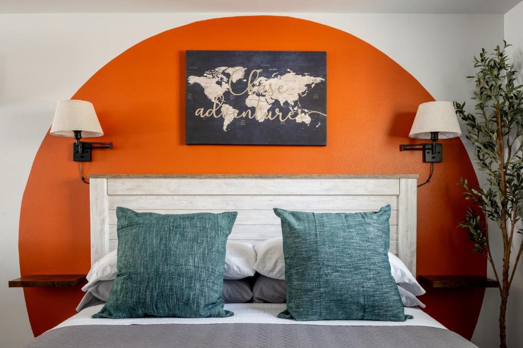 een oranje muur boven een bed met twee kussens bij McKamy Cottage at Wrenwood Ranch, King Bed in Johnson City