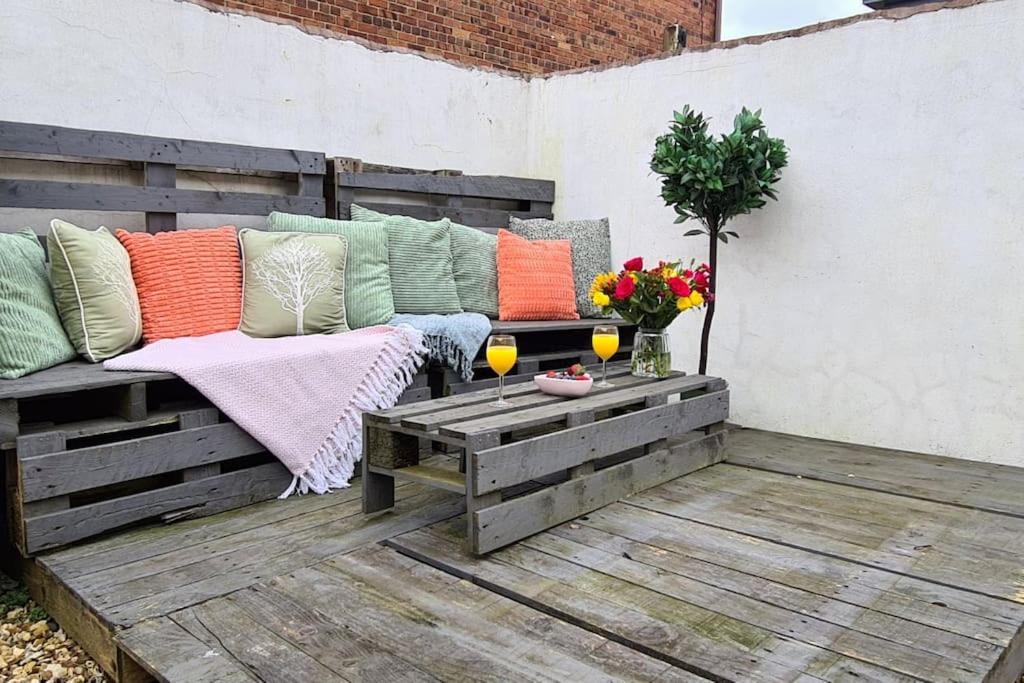 a bench with colorful pillows on a patio at Jasper's by Spires Accommodation a great base to stay for Alton Towers and corporate clientele working away from home in Stoke on Trent