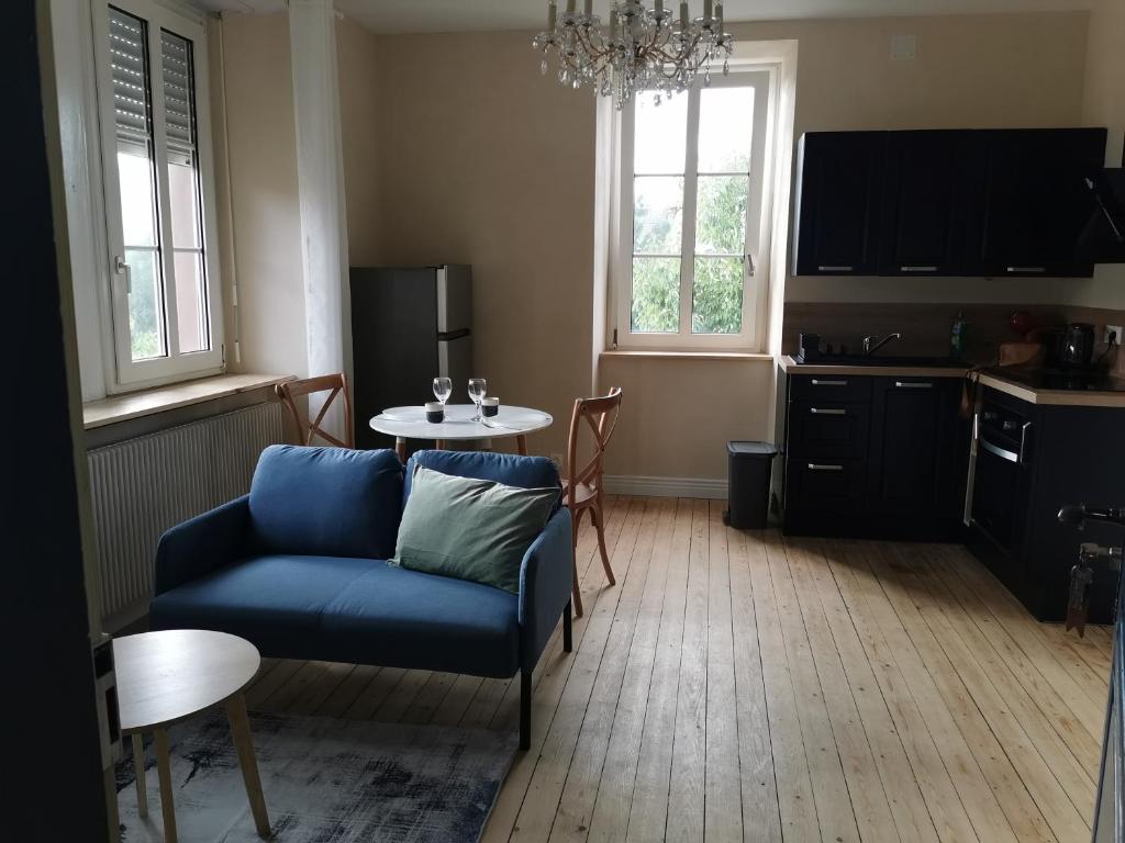 - un salon avec un canapé bleu et une table dans l'établissement Appartement au calme RDC jardin, à Wasselonne