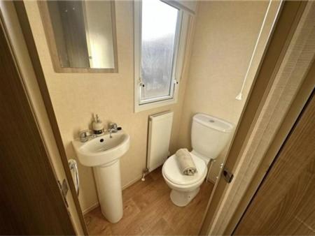 een kleine badkamer met een toilet en een wastafel bij The Derwent in Prestatyn