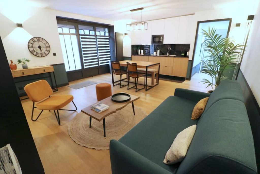 un salon avec un canapé vert et une table dans l'établissement Cocon neuf - Coeur du 11e, à Paris