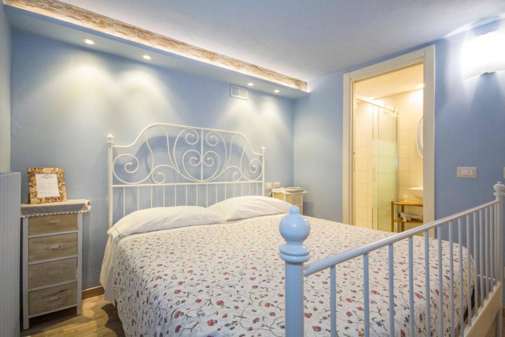 a bedroom with a white bed and a blue wall at La Contrada B&B in Casnate con Bernate