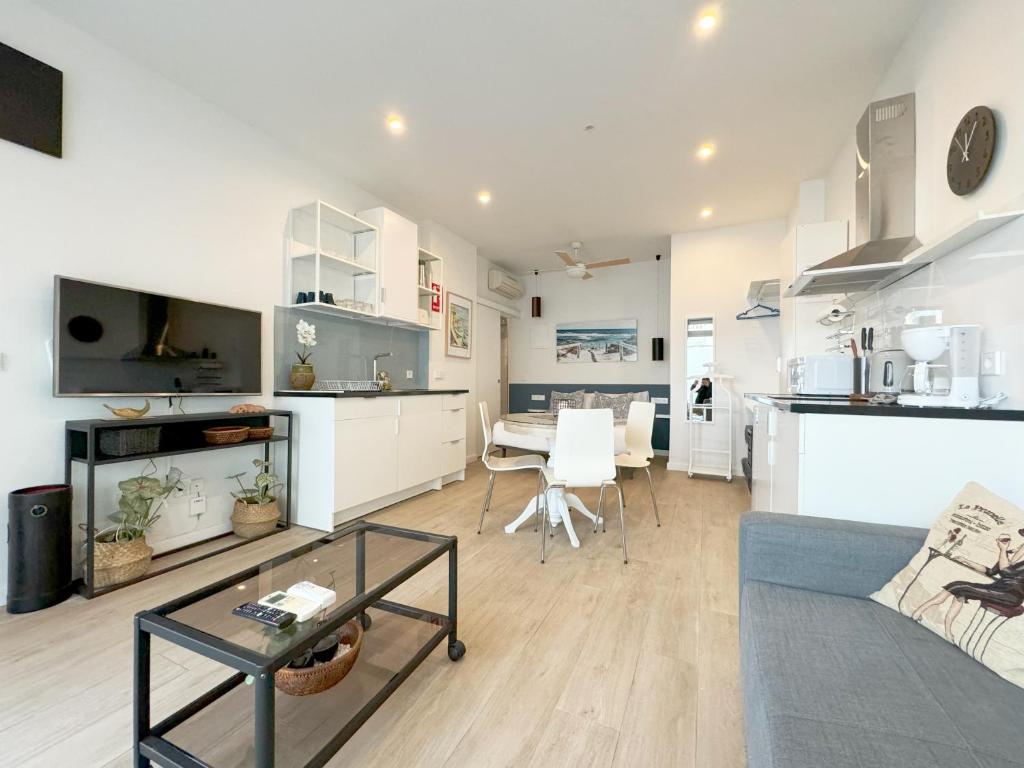eine Küche und ein Wohnzimmer mit einem Sofa und einem Tisch in der Unterkunft Luminoso, cómodo y buena zona in Madrid