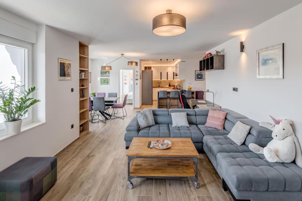 a living room with a blue couch and a table at Bells & Whistles, Comfortable Condo in Split