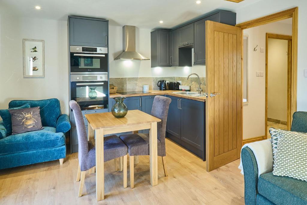 a kitchen and living room with a table and chairs at Host & Stay - Willow Barn in Aldington