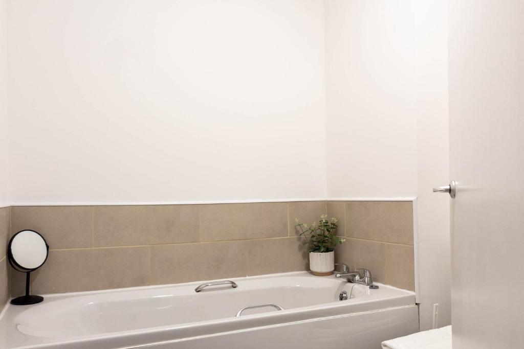 - białą wannę w łazience z lustrem w obiekcie Dubbie House w mieście Leven