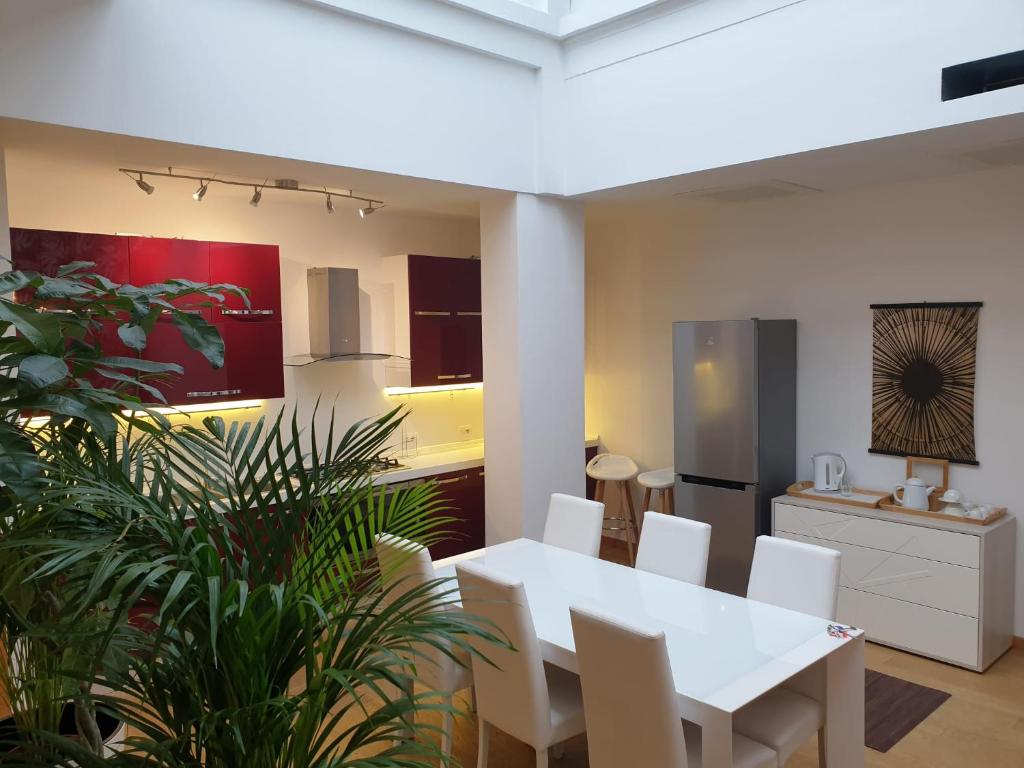 uma sala de jantar com uma mesa branca e cadeiras brancas em Aparthotel Dei Mercanti em Milão