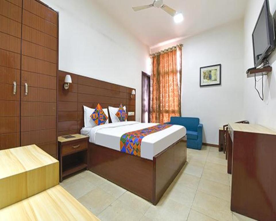 Un dormitorio con una cama y un televisor. en FabHotel Jaipur Casa, en Jaipur