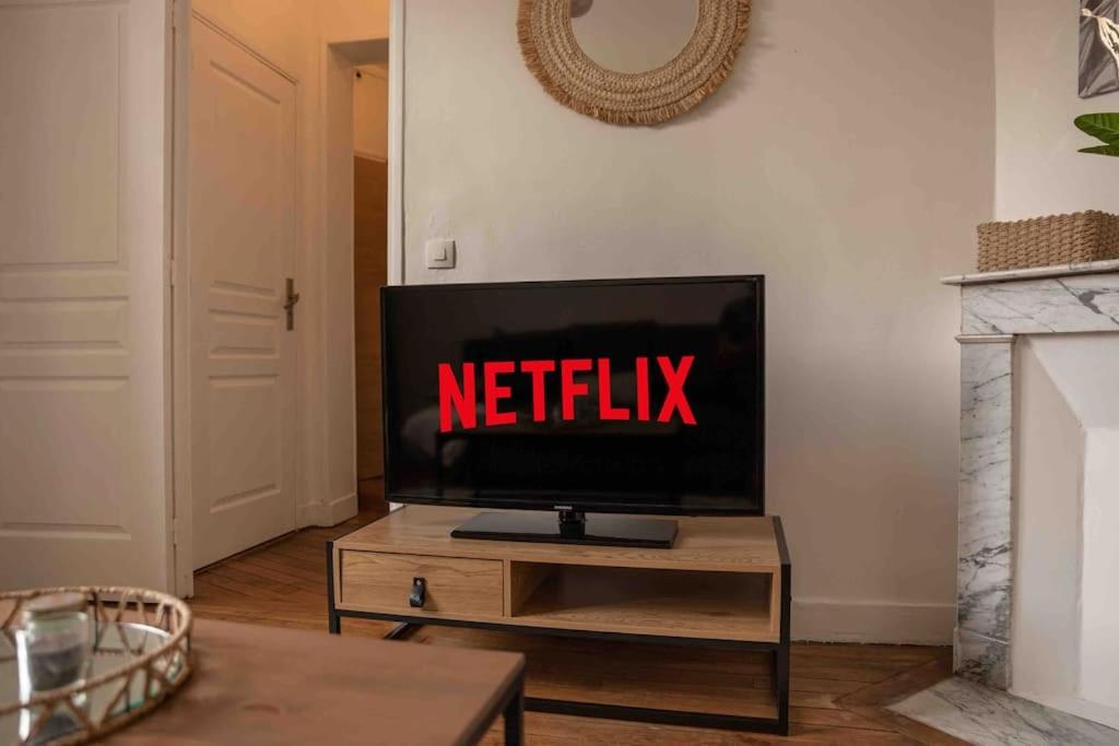a tv sitting on a table in a living room at Appartement chic proche gare de Clamart + Netflix in Malakoff