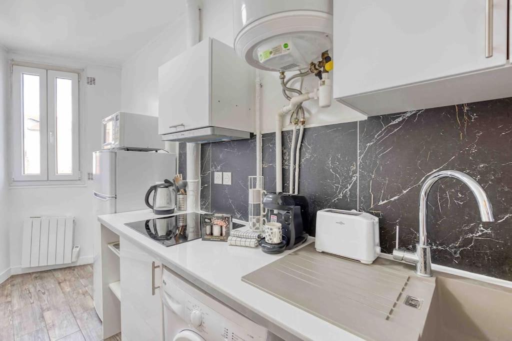 a kitchen with white cabinets and a counter top at Appartement chic proche gare de Clamart + Netflix in Malakoff