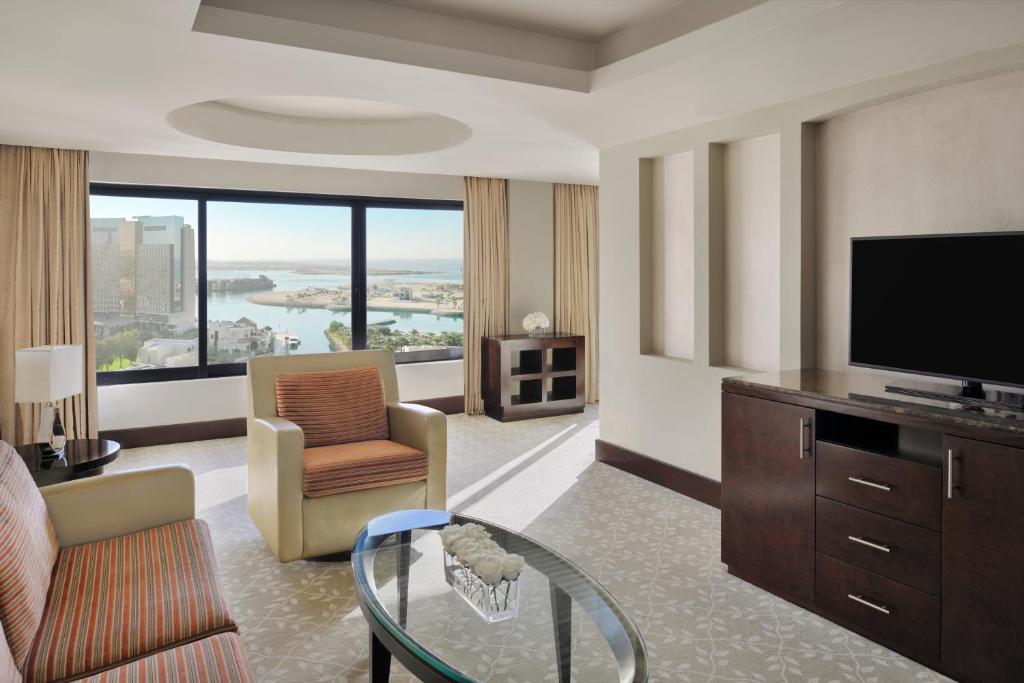 a living room with a flat screen tv and a living room with a view at InterContinental Abu Dhabi by IHG in Abu Dhabi