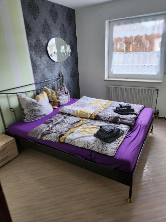 a bedroom with a bed with purple sheets and a window at Ferienwohnung Metz in Waldberg