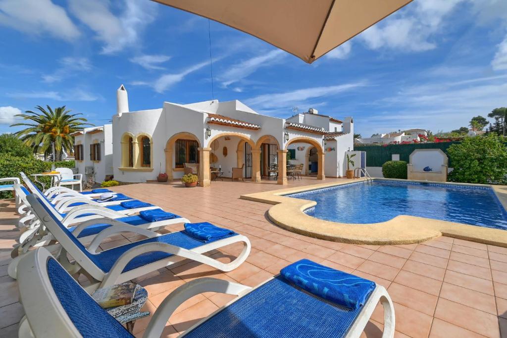 uma villa com uma piscina e espreguiçadeiras em Arearea em Xàbia