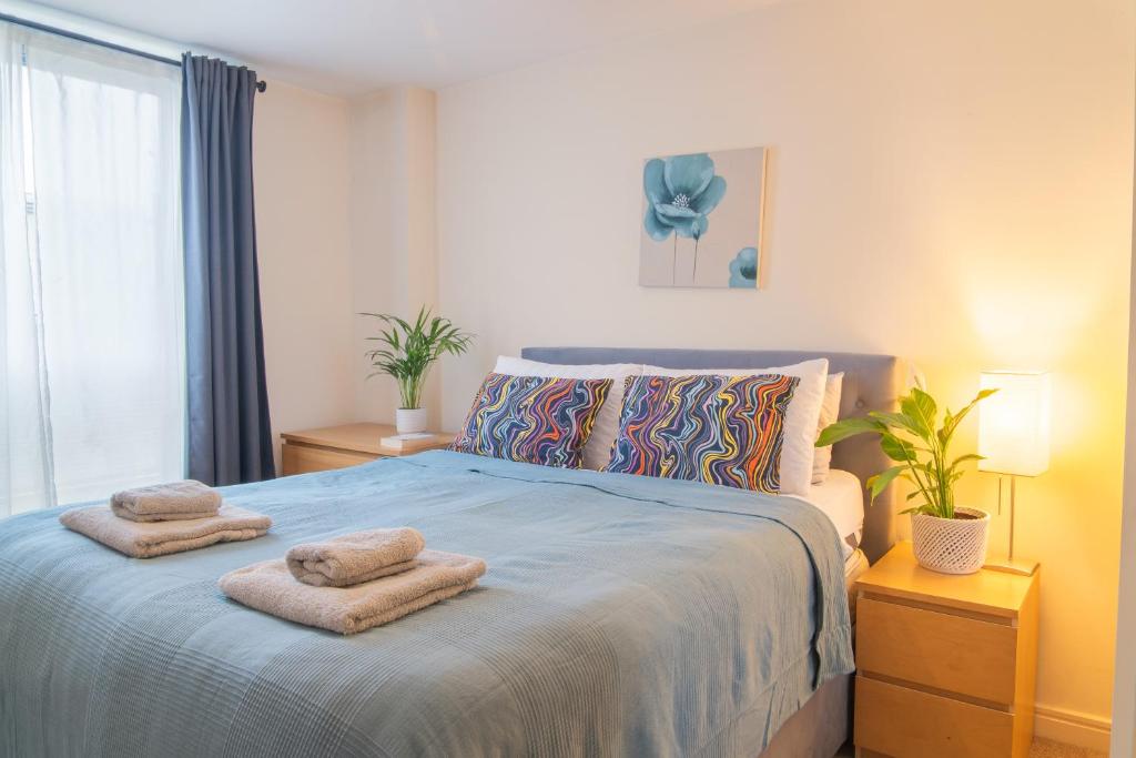 a bedroom with a bed with two towels on it at Stay in our Stylish Flat! & Parking & secure building & sleeps up to 4 in Birmingham