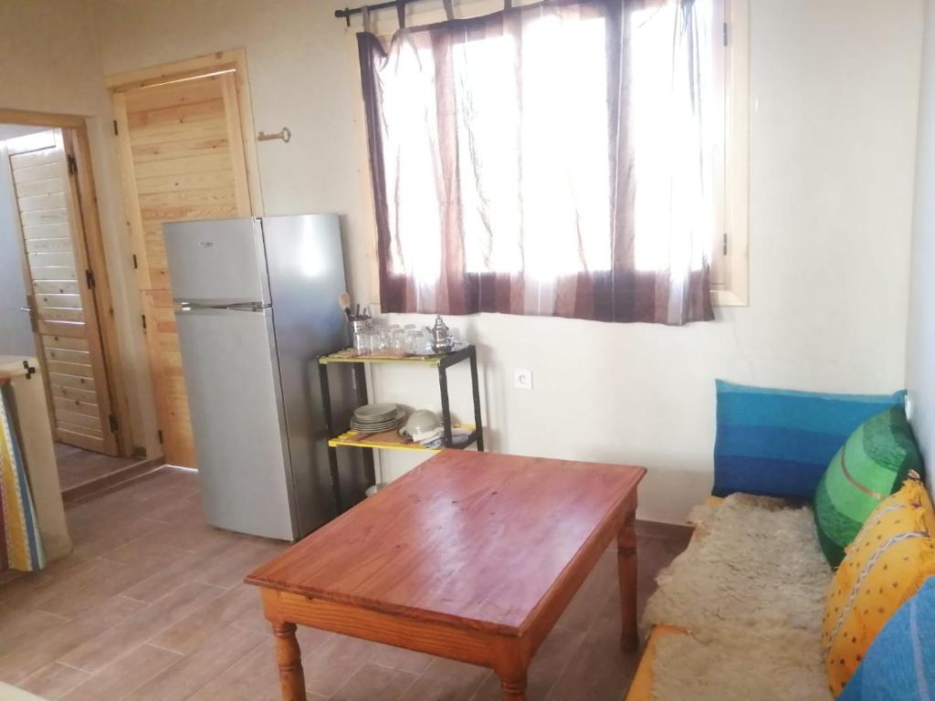 cocina con nevera y mesa en una habitación en Jolie Appartement, en Agadir