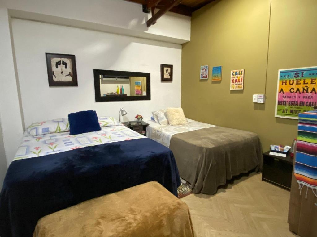 a room with two beds and a mirror at Apartarstudio muy bien ubicado, cercano a todo!! in Cali