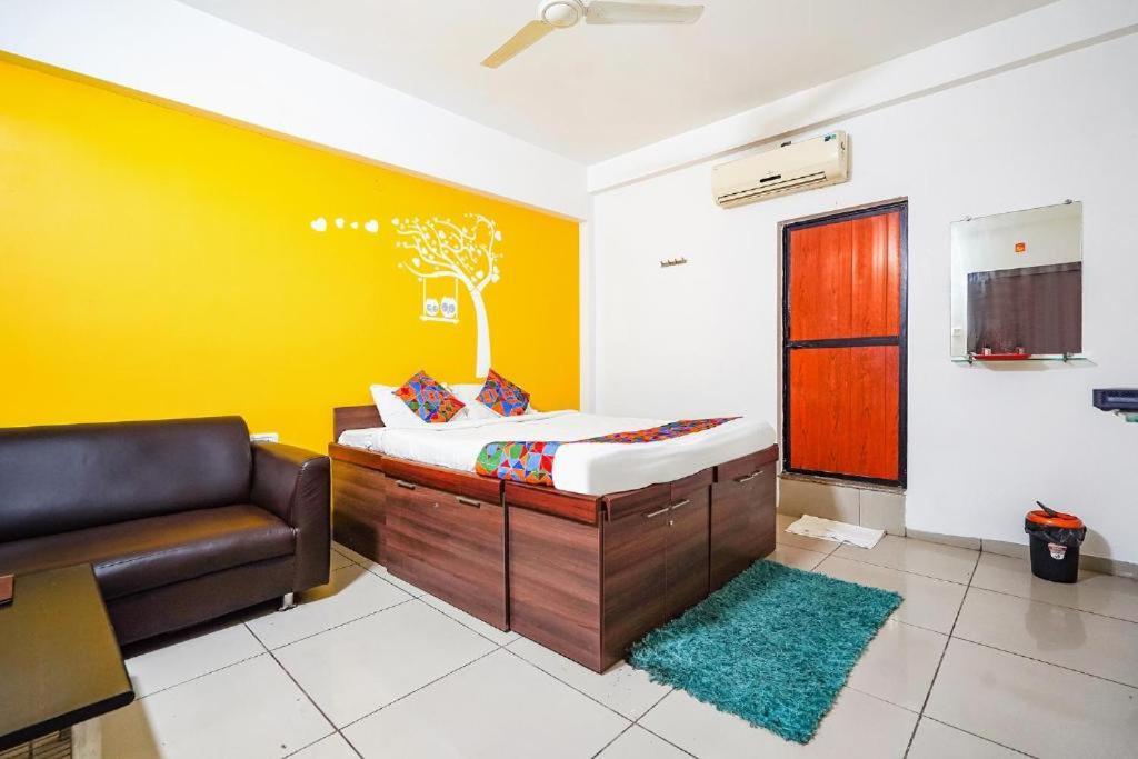 a living room with a couch and a yellow wall at Hotel JK Lions - Koradi, Nagpur in Nagpur