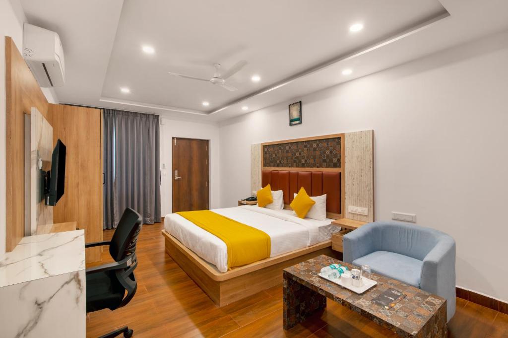 バンガロールにあるGateway Premium Innのベッドと椅子付きのホテルルーム