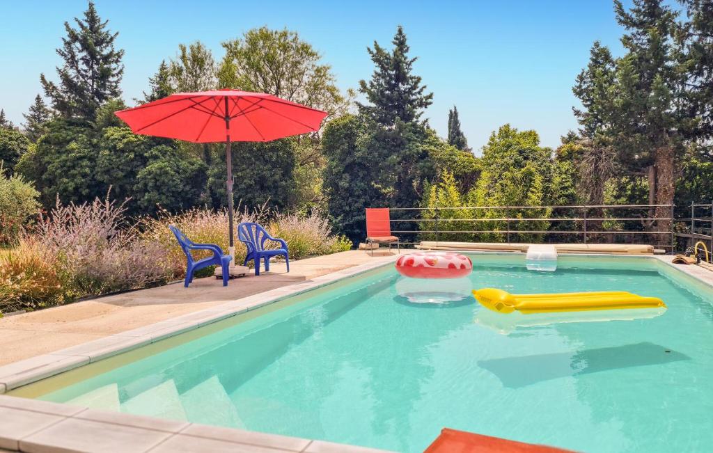 een zwembad met een parasol en stoelen en een zwembad bij Beautiful Home In Velleron With House A Panoramic View in Velleron