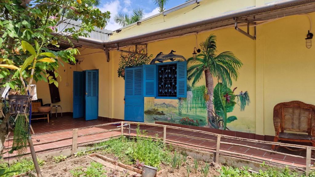 ein Wandbild an der Seite eines Hauses mit Palmen in der Unterkunft Masawi Home in Cần Thơ