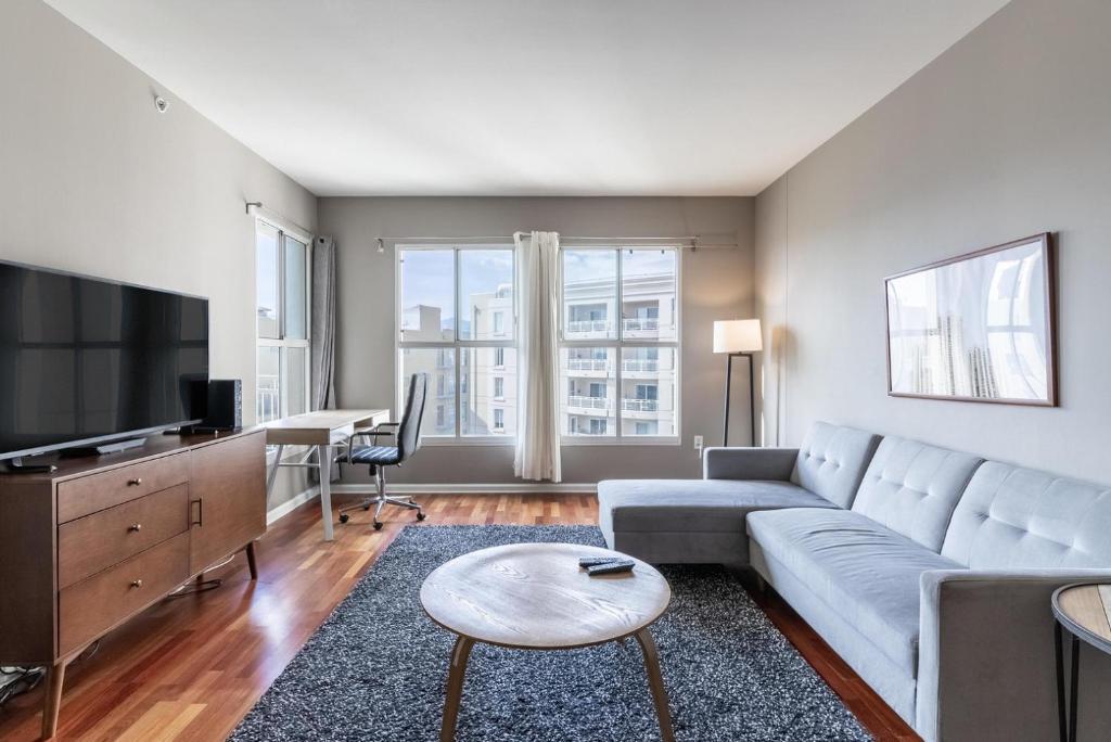 a living room with a couch and a tv at Blueground Hayes Valley balcony gym nr dining SFO-1679 in San Francisco