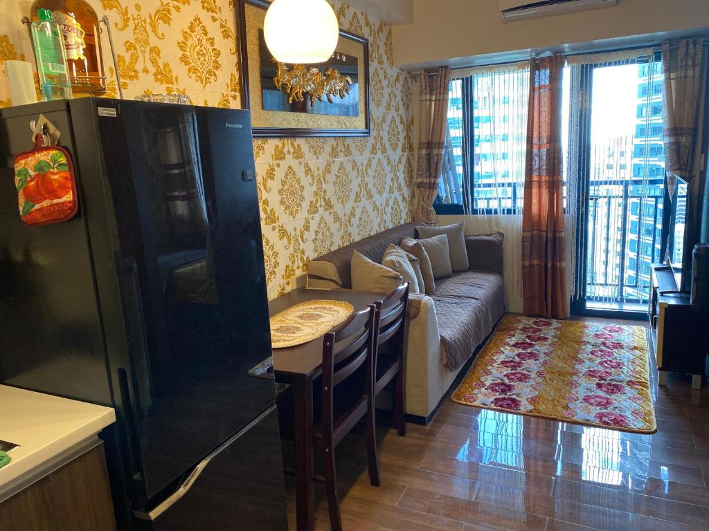 a kitchen and living room with a couch and a table at Luxury Urban Bliss-Stylish 3 Bedroom 4room Makati Oasis in Air residence in Manila