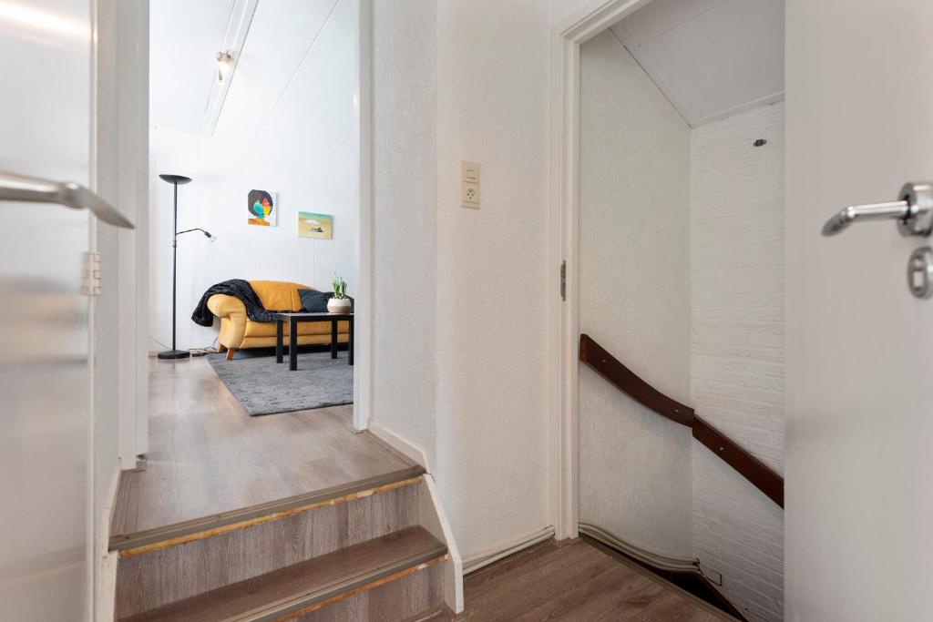 un couloir avec un escalier menant au salon dans l'établissement De Entos, à Zandvoort
