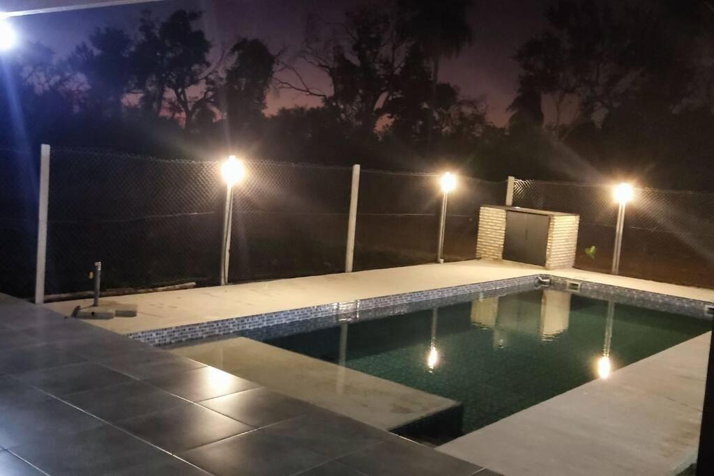 a swimming pool at night with lights on a fence at Casa Quincho con Piscina in Luque
