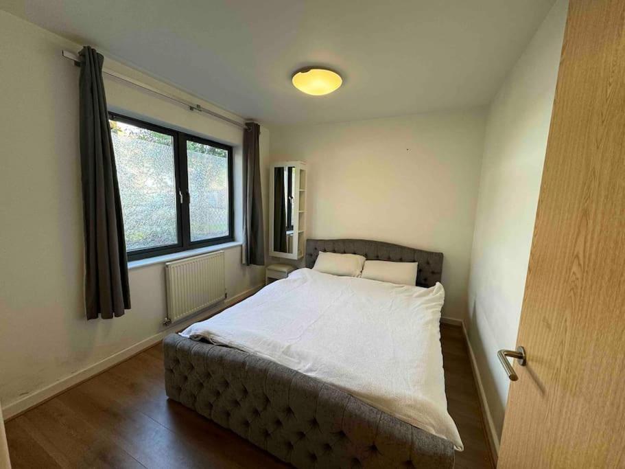 um quarto com uma cama num quarto com uma janela em Large Two Bed Maisonette next to Station em Brentwood