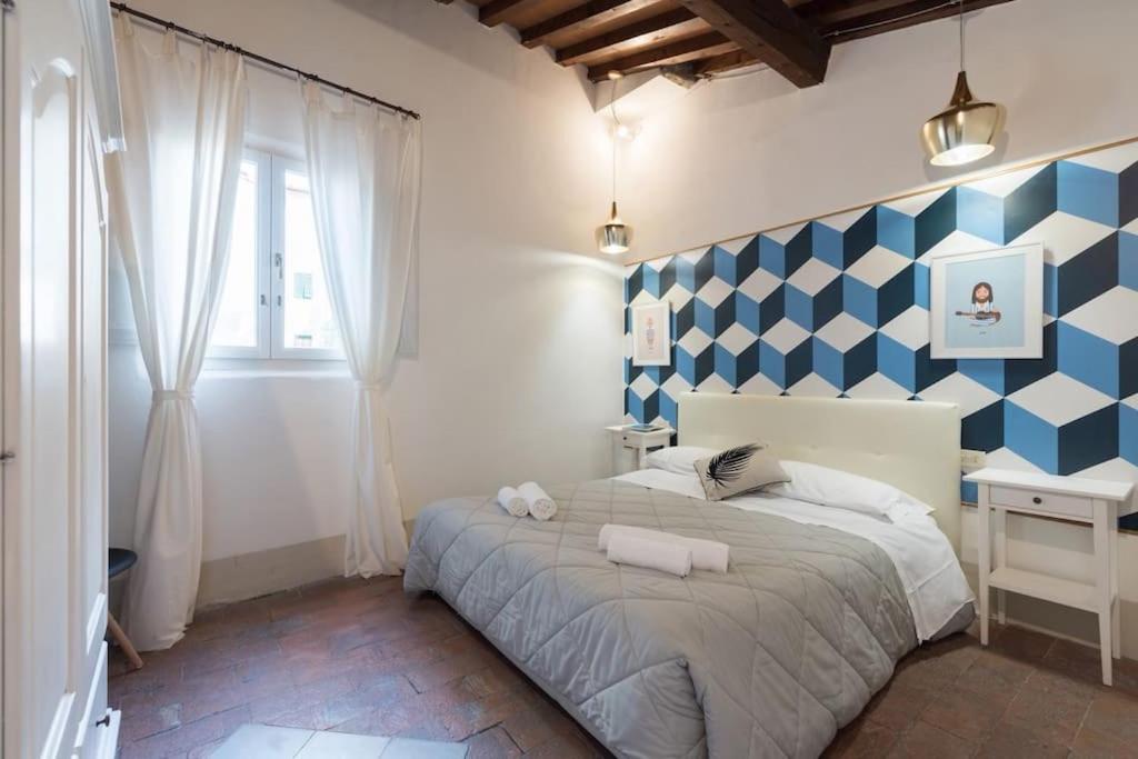 ein Schlafzimmer mit einem Bett mit einer blau-weißen, karierten Wand in der Unterkunft F5 -Santa Croce one bedroom flat 2 to 4 guests in Florenz