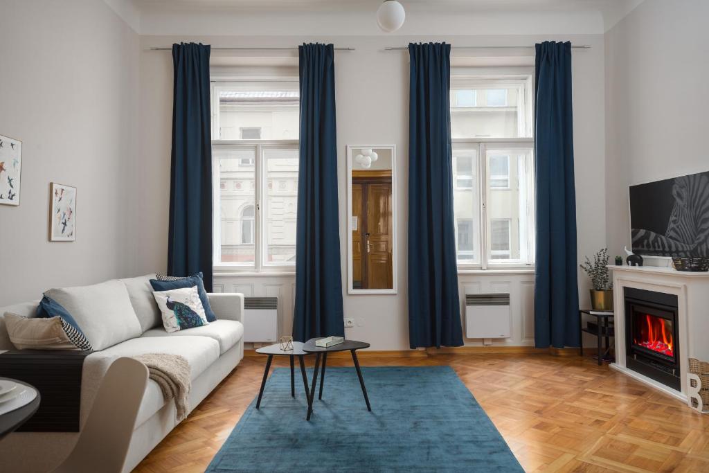 a living room with a couch and a fireplace at AIRSTAY PRAGUE apartment Vinohrady in Prague