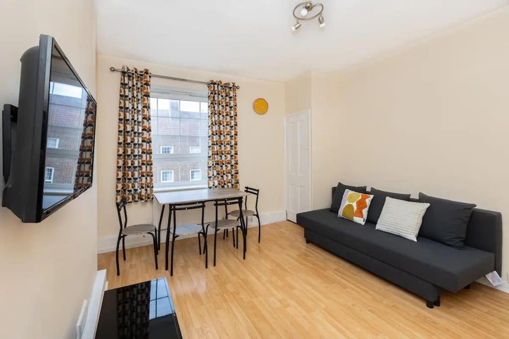 a living room with a couch and a table at Tranquil 1BR in South Bank with onsite parking in London