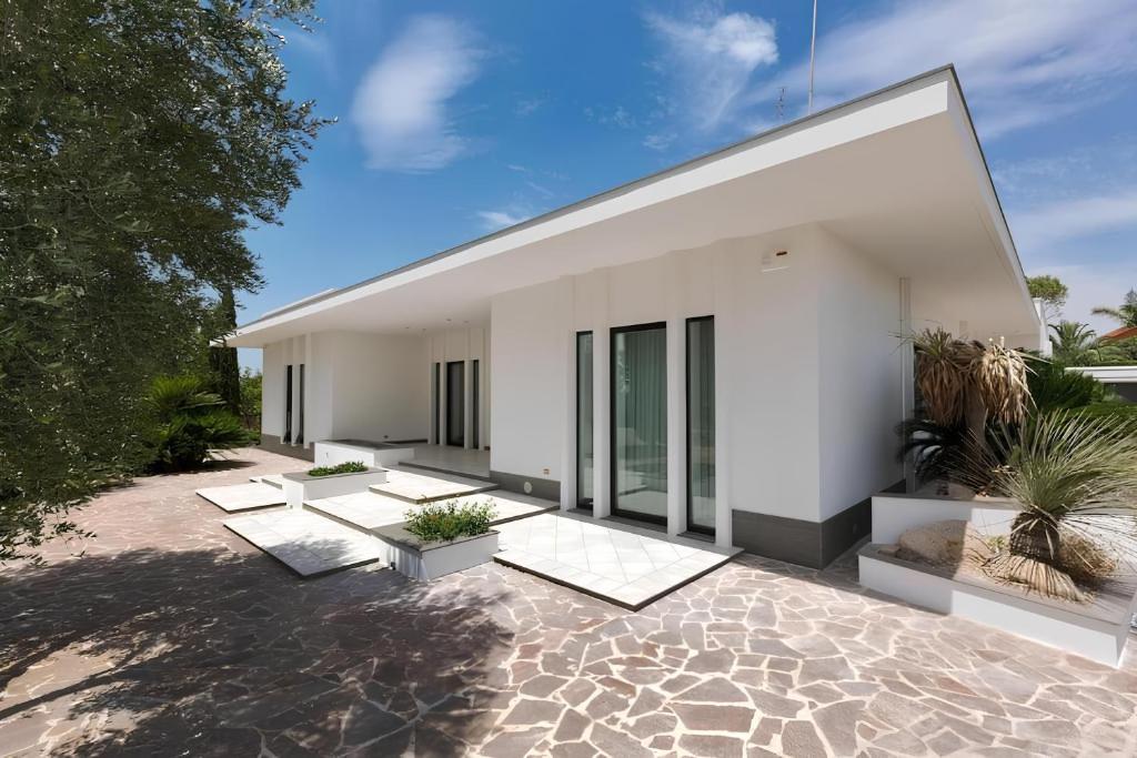 a white house with a courtyard with potted plants at Villa Elena, Galatina (LE) in Galatina