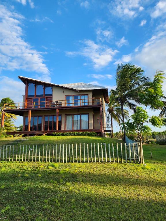 uma casa com uma cerca em frente em Vila Ybytu Eco Resort em Itarema