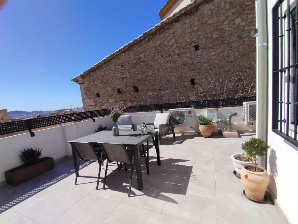 eine Terrasse mit einem Tisch und Stühlen auf dem Balkon in der Unterkunft Apartamentos Elegancia in Agost