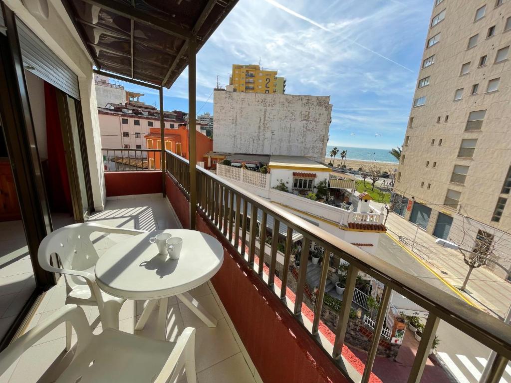 a balcony with a table and a view of a city at Apartamentos Playa Oropesa 3000 in Oropesa del Mar