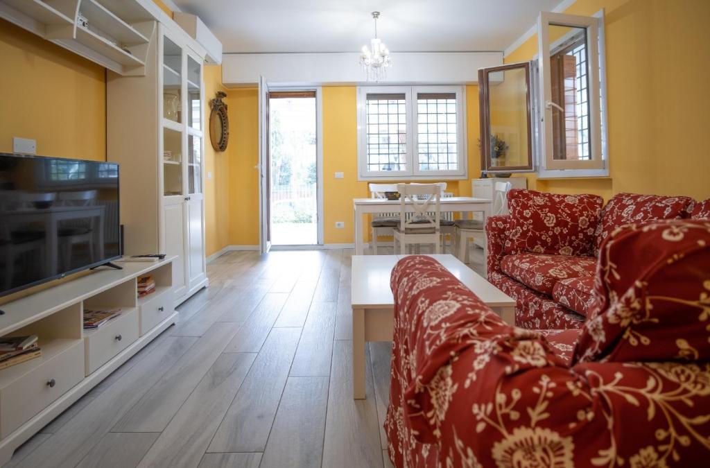 uma sala de estar com um sofá e uma televisão em grande appartamento zona viale ceccarini con giardino em Riccione