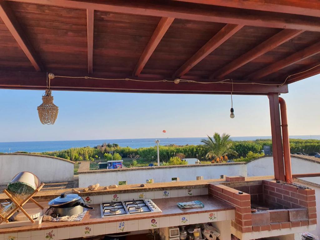 una cocina al aire libre con vistas al océano en Salentoandmore - Appartamento con attico, en Marina di Pescoluse
