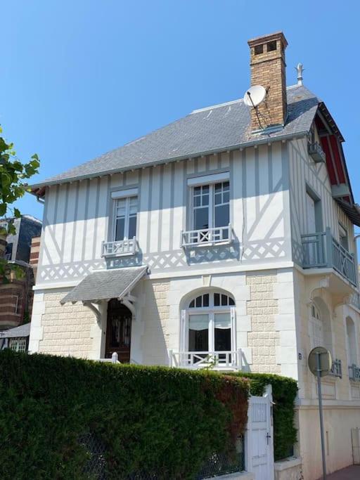une maison blanche avec une cheminée en haut dans l'établissement Villa Soleil Levant, à Deauville