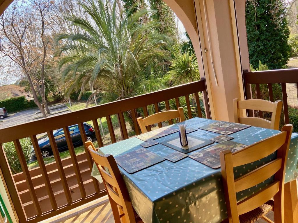 - une table sur un balcon avec vue sur un palmier dans l'établissement Bastide, à Saint-Cyprien