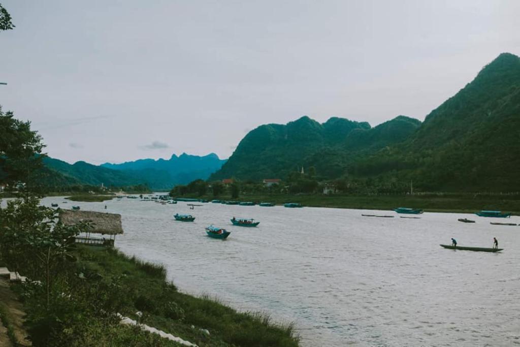 een groep boten op een rivier met bergen bij Riverview Home in Quang Binh