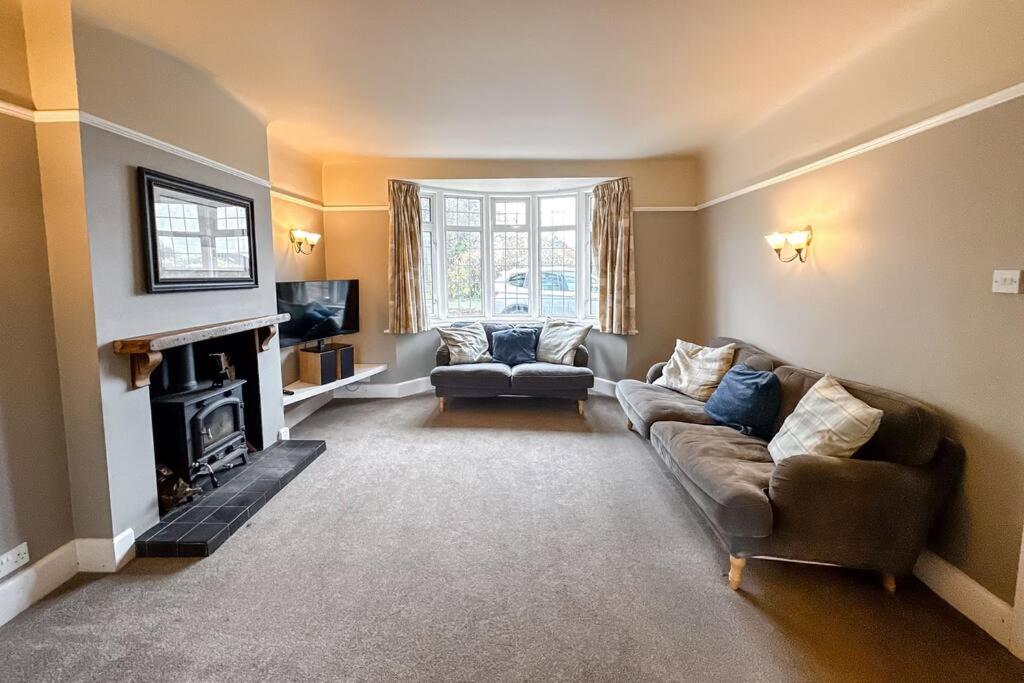 sala de estar con 2 sofás y chimenea en Stunning house, sleeps 10, garden and pool table - West Parley Manor, en West Parley