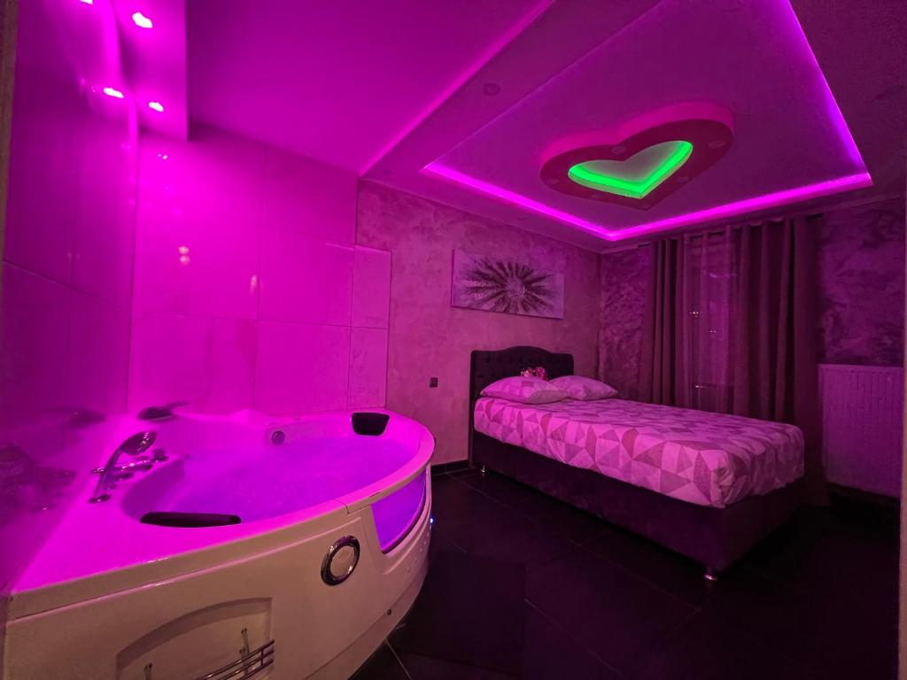 a purple room with a bath tub and a bed at Nid d'Amour in Strasbourg