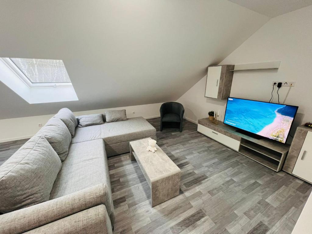 Il comprend un salon doté d'un canapé et d'une télévision à écran plat. dans l'établissement Apartment Weikersheim II, à Weikersheim