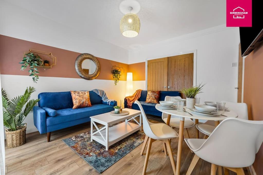 ein Wohnzimmer mit einem blauen Sofa und einem Tisch in der Unterkunft Accessible ground floor wet room and bedroom in a modern 4 Bedroom House-B28 Hall Green in Birmingham